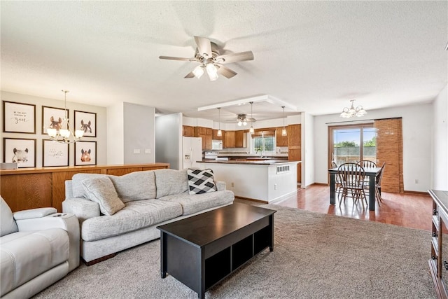 4185 Richland Dr, Cedar Rapids, IA 52405 - living area featuring a chandelier, a ceiling fan, a textured ceiling, and light carpet