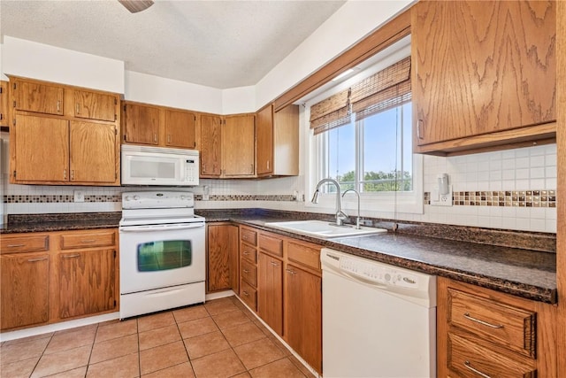 4185 Richland Dr, Cedar Rapids, IA 52405 - kitchen with white appliances, dark countertops, brown cabinetry, and decorative backsplash