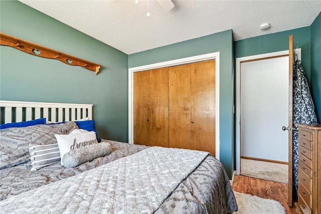 4185 Richland Dr, Cedar Rapids, IA 52405 - bedroom featuring a closet, wood finished floors, a textured ceiling, and a ceiling fan