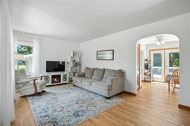 1039 27th St NE, Cedar Rapids, IA 52214 - living room featuring arched walkways, light wood finished floors, and french doors