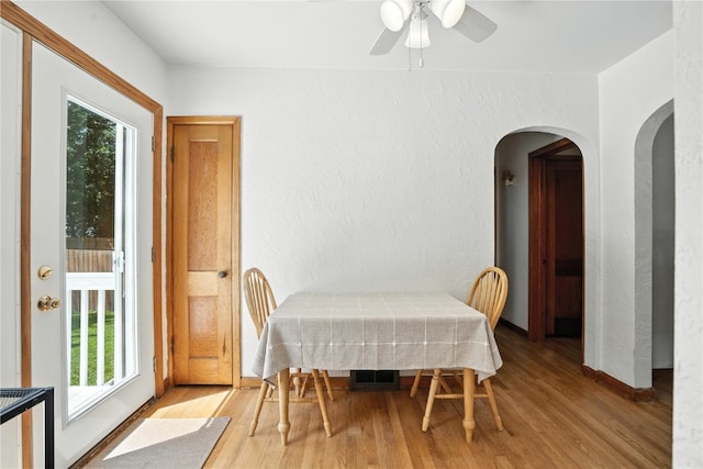 1039 27th St NE, Cedar Rapids, IA 52214 - dining area with light wood-type flooring, a textured wall, arched walkways, and ceiling fan