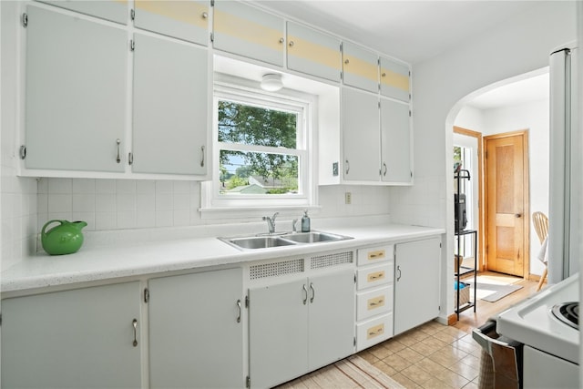 1039 27th St NE, Cedar Rapids, IA 52214 - kitchen featuring arched walkways, backsplash, white range oven, and light countertops