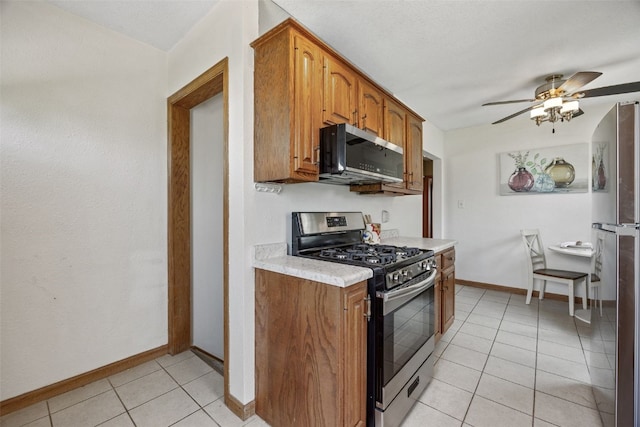 2226 Chandler SW, Cedar Rapids, IA 52404 - kitchen with stainless steel appliances, light countertops, ceiling fan, brown cabinetry, and light tile patterned floors
