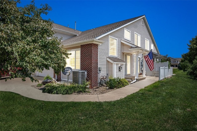 1167 74th St NE, Cedar Rapids, IA 52402 - view of home's exterior featuring roof with shingles, a lawn, and brick siding