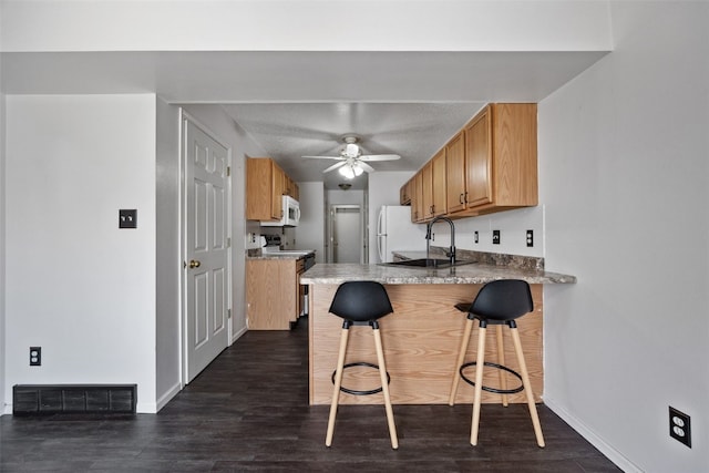 1167 74th St NE, Cedar Rapids, IA 52402 - kitchen with ceiling fan, a peninsula, a kitchen breakfast bar, range with electric cooktop, and dark wood finished floors
