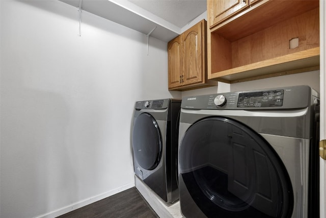 1167 74th St NE, Cedar Rapids, IA 52402 - laundry room featuring cabinet space, washing machine and clothes dryer, and dark wood-type flooring