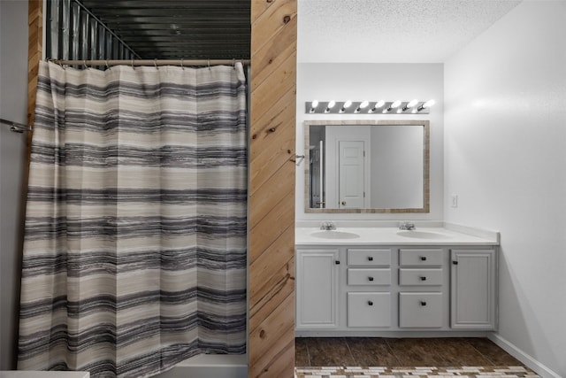1167 74th St NE, Cedar Rapids, IA 52402 - bathroom featuring double vanity, a shower with curtain, and a textured ceiling