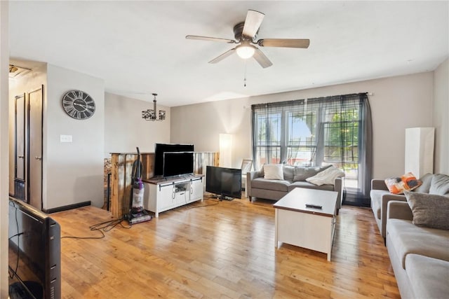 1638 47th St NE, Cedar Rapids, IA 52402 - living room featuring light wood-style flooring, ceiling fan, and a chandelier