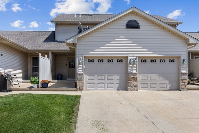 3221 English Cove Ln, Marion, IA 52302 - traditional-style home with a garage, concrete driveway, a shingled roof, and stone siding
