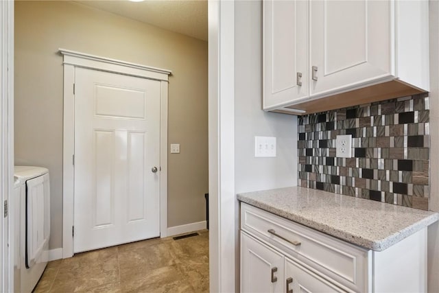 1627 Settlers Dr, Marion, IA 52302 - kitchen with washer and dryer, tasteful backsplash, white cabinetry, and light stone counters