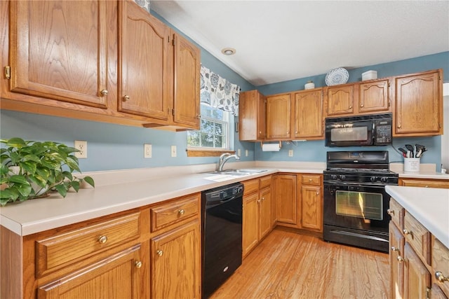 405 Stoney Creek Rd NW, Cedar Rapids, IA 52405 - kitchen featuring black appliances, light wood-style floors, light countertops, brown cabinets, and vaulted ceiling