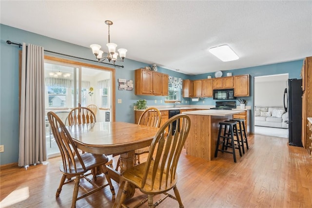 405 Stoney Creek Rd NW, Cedar Rapids, IA 52405 - dining room featuring light wood-type flooring, a chandelier, and a textured ceiling