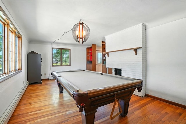 2153 Echo Hill Rd, Marion, IA 52302 - playroom with a baseboard heating unit, billiards, light wood finished floors, a fireplace, and a chandelier