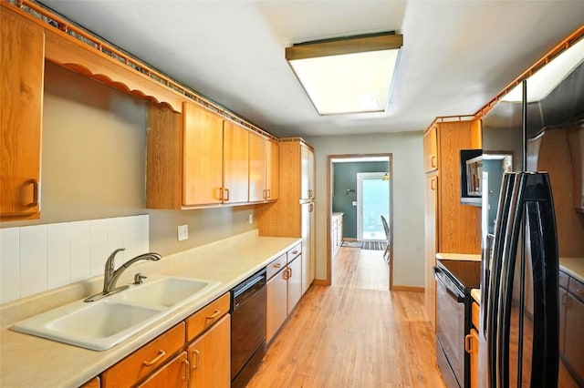 2153 Echo Hill Rd, Marion, IA 52302 - kitchen with black appliances, light countertops, light wood finished floors, and brown cabinetry