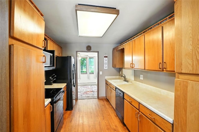 2153 Echo Hill Rd, Marion, IA 52302 - kitchen with black appliances, light wood finished floors, light countertops, brown cabinetry, and a baseboard heating unit