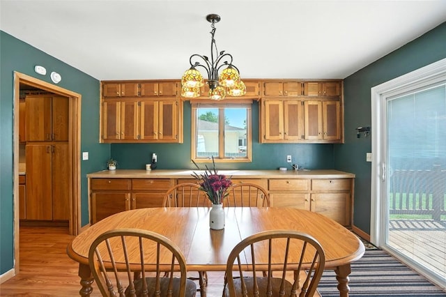 2153 Echo Hill Rd, Marion, IA 52302 - kitchen featuring light countertops, a chandelier, light wood-style floors, decorative light fixtures, and brown cabinetry