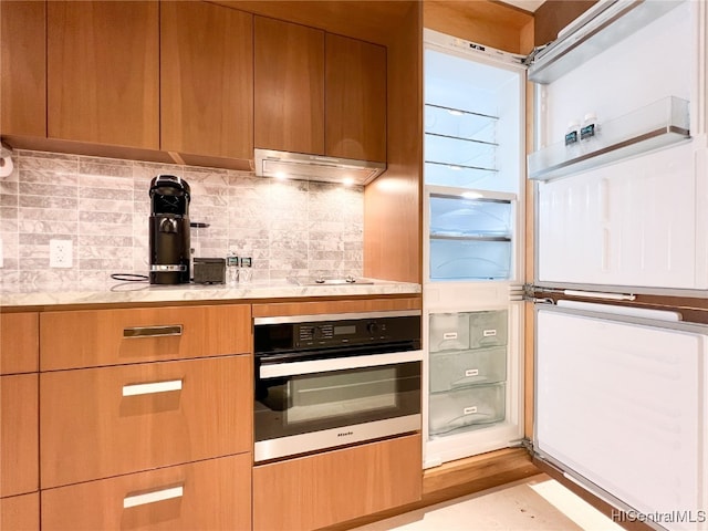 kitchen with stainless steel oven and decorative backsplash