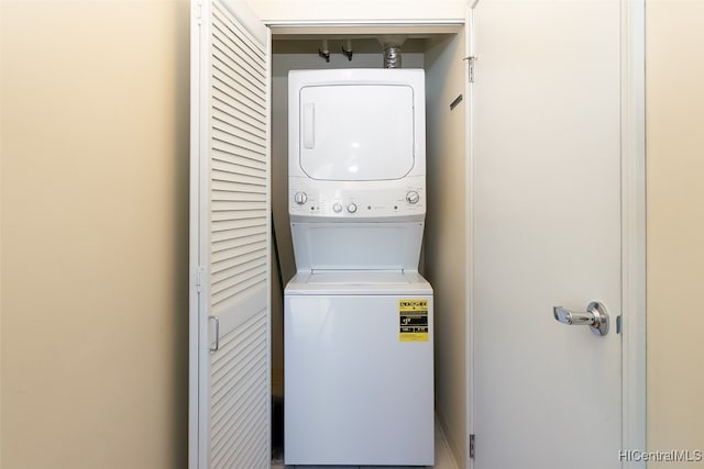 clothes washing area with stacked washer / dryer