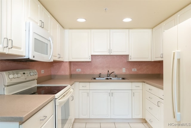 kitchen with tasteful backsplash, light tile patterned floors, white cabinetry, sink, and white appliances