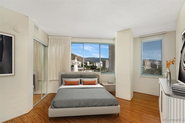 bedroom featuring a closet, a textured ceiling, and hardwood / wood-style flooring