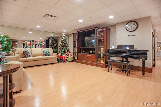 living room featuring hardwood / wood-style flooring and a drop ceiling