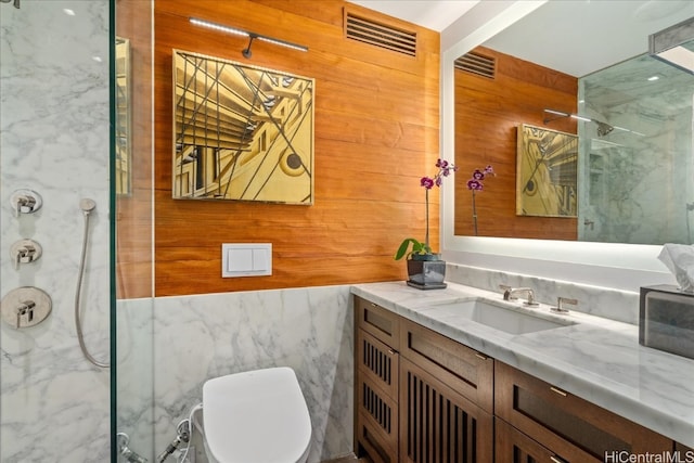 bathroom featuring toilet, walk in shower, tile walls, wooden walls, and vanity