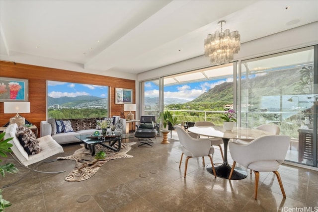 sunroom / solarium featuring a notable chandelier and a mountain view