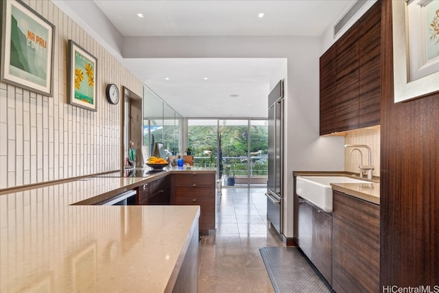 kitchen featuring a wall of windows, stainless steel built in refrigerator, sink, and black electric cooktop