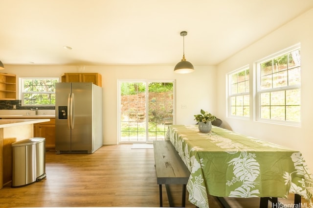 dining area with light hardwood / wood-style floors, sink, and plenty of natural light