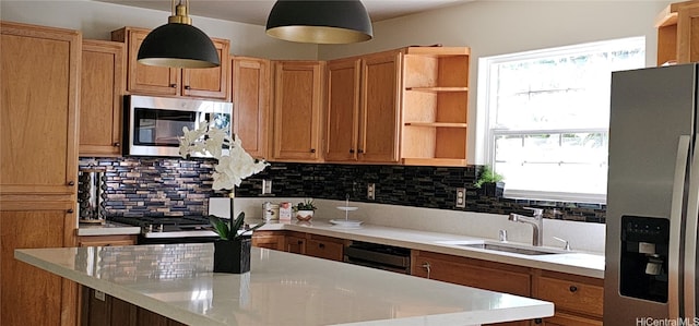 kitchen featuring sink, appliances with stainless steel finishes, hanging light fixtures, and tasteful backsplash