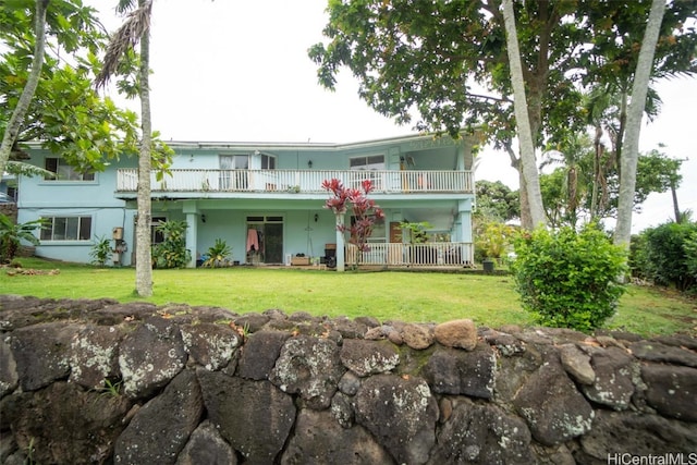 view of front of property featuring a balcony and a front lawn