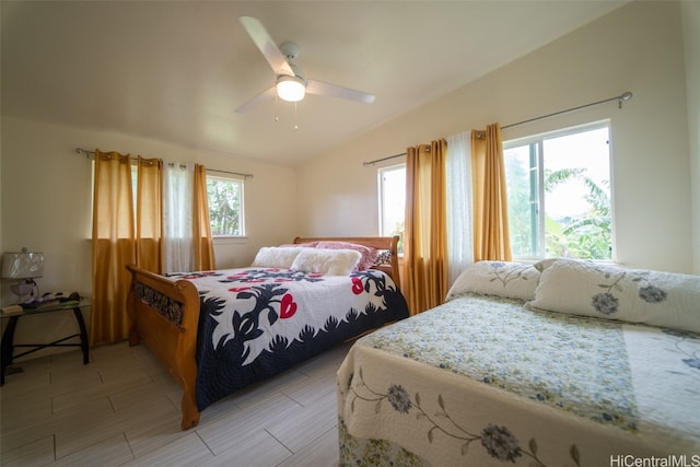 bedroom with vaulted ceiling, multiple windows, and ceiling fan