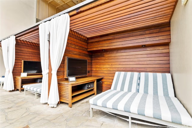 interior space featuring wooden ceiling and wooden walls