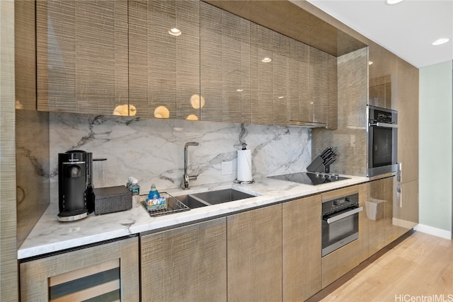 kitchen featuring sink, wine cooler, stainless steel oven, and light hardwood / wood-style flooring