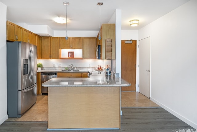 kitchen featuring light hardwood / wood-style flooring, hanging light fixtures, stainless steel appliances, and sink