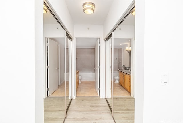 hallway with light hardwood / wood-style floors and sink