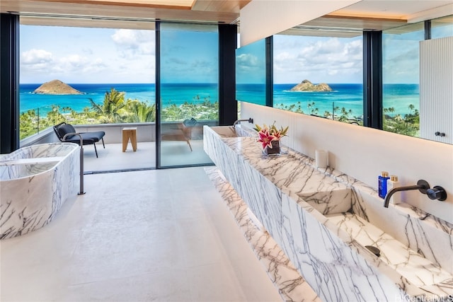 bedroom featuring a water view and expansive windows