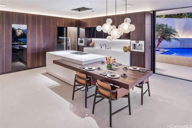 kitchen with dark brown cabinetry and pendant lighting