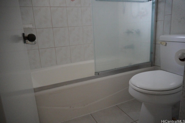 bathroom with tile patterned floors, combined bath / shower with glass door, and toilet