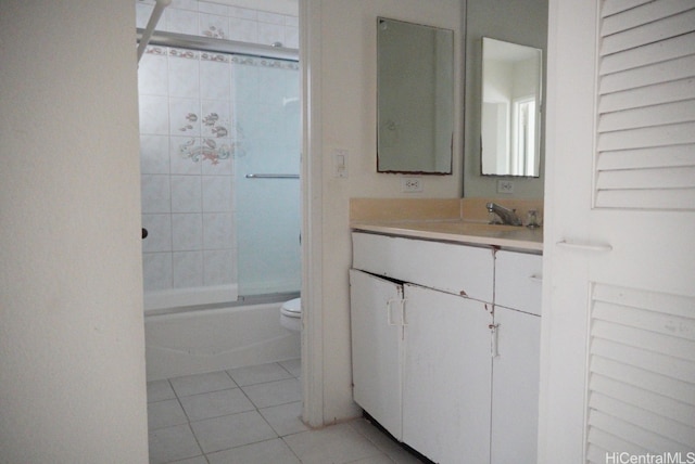 full bathroom with vanity, bath / shower combo with glass door, toilet, and tile patterned floors