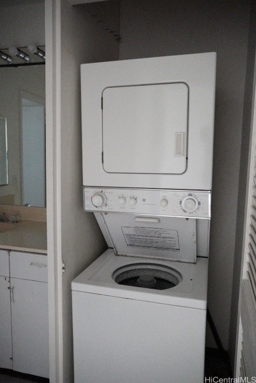 clothes washing area featuring stacked washer and clothes dryer