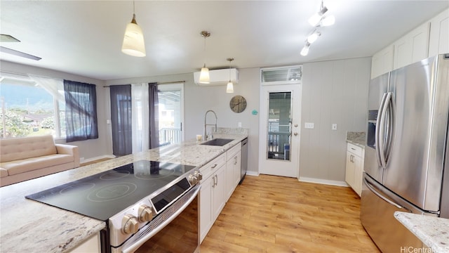 kitchen featuring pendant lighting, sink, white cabinetry, and appliances with stainless steel finishes