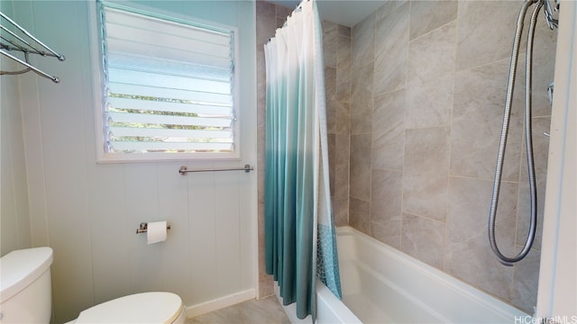 bathroom featuring shower / bathtub combination with curtain and toilet