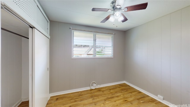 unfurnished bedroom with wood-type flooring, a closet, and ceiling fan