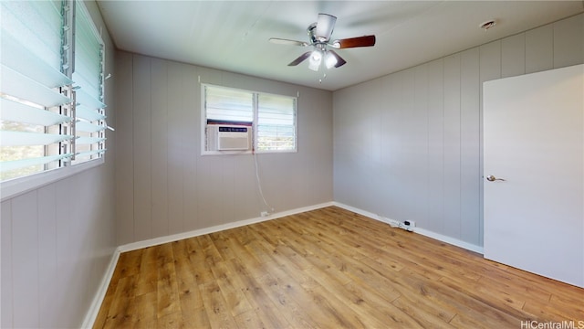 empty room featuring ceiling fan, cooling unit, and light hardwood / wood-style floors