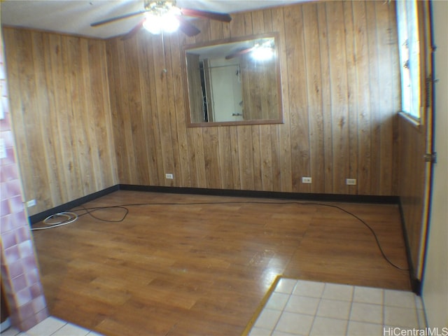 unfurnished room with ceiling fan, basketball hoop, wood-type flooring, and wood walls