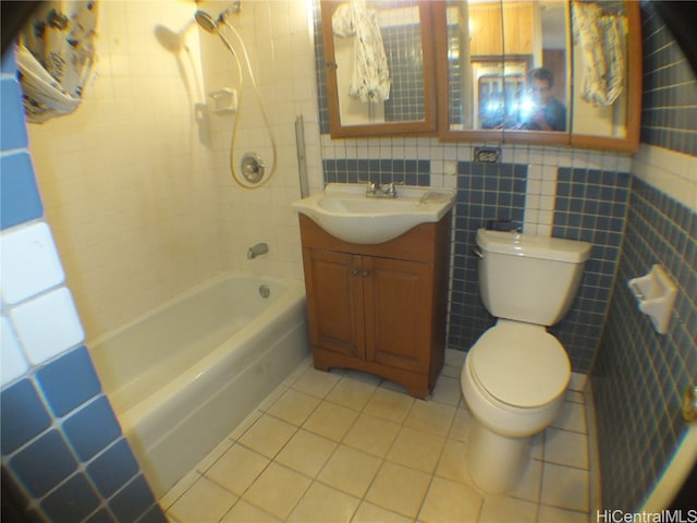 full bathroom featuring vanity, toilet, tile walls, and tiled shower / bath