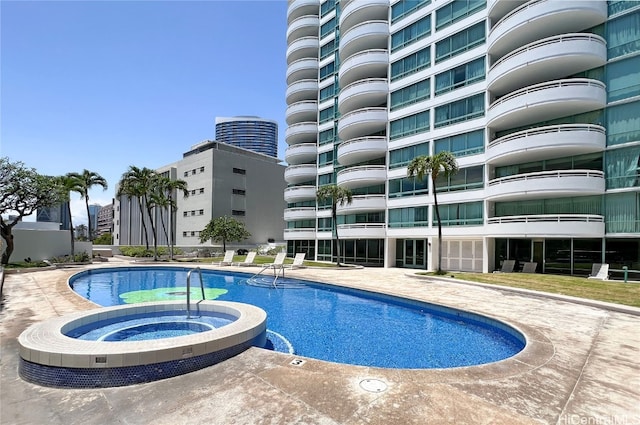 pool featuring a community hot tub and a patio area