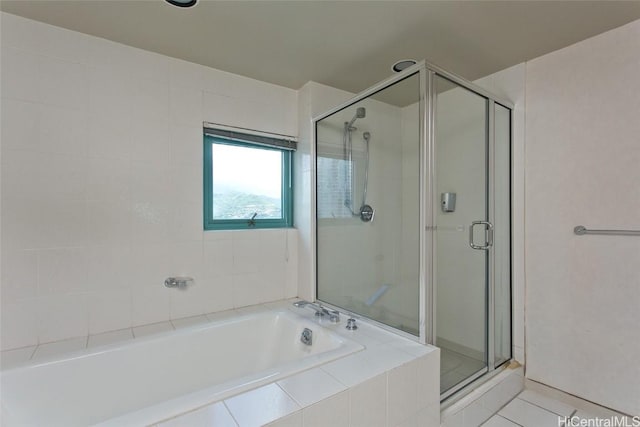 full bath featuring a stall shower, a garden tub, and tile patterned floors