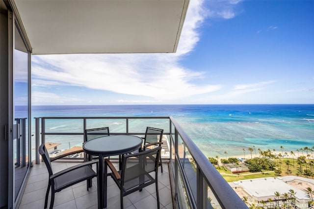 balcony with a water view and a view of the beach